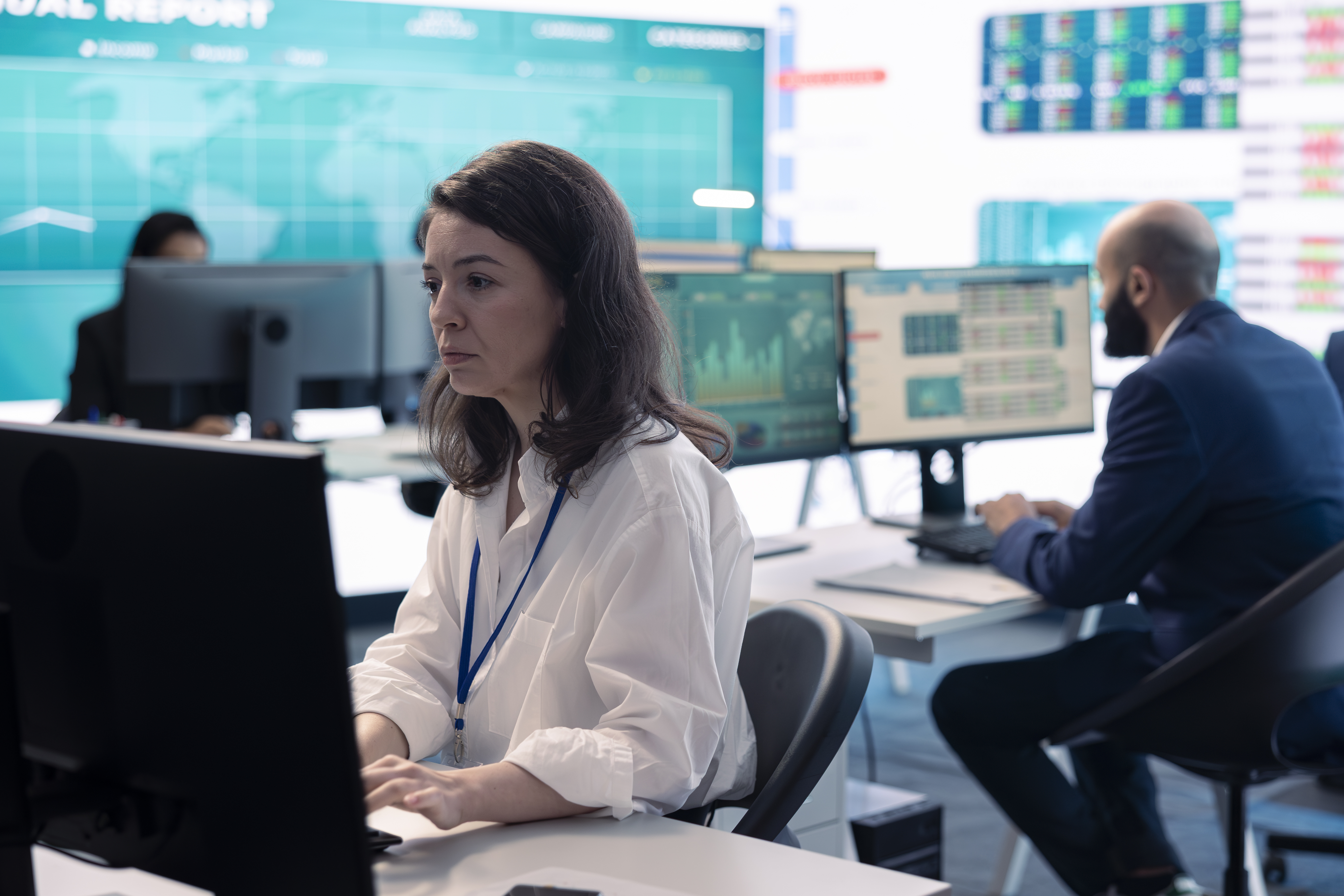 IT operations team managing multiple systems on screens in office